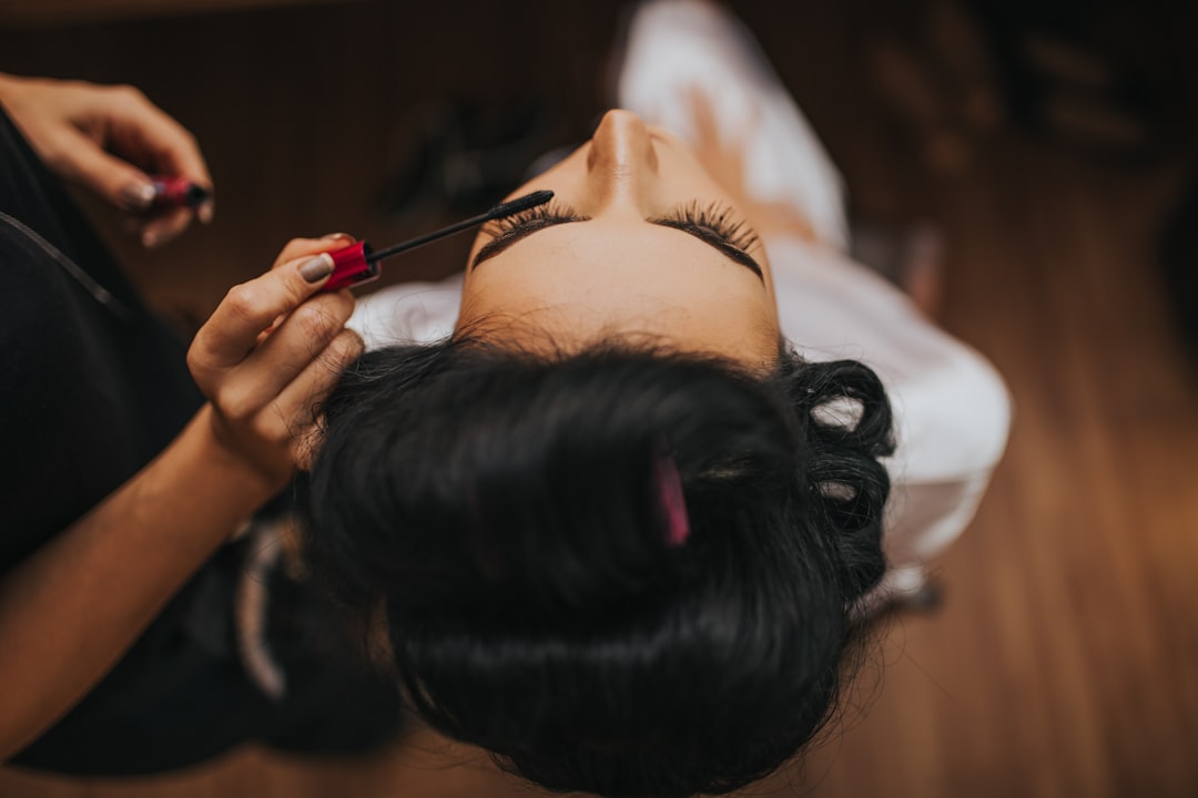 Woman applying mascara to her eyelashes