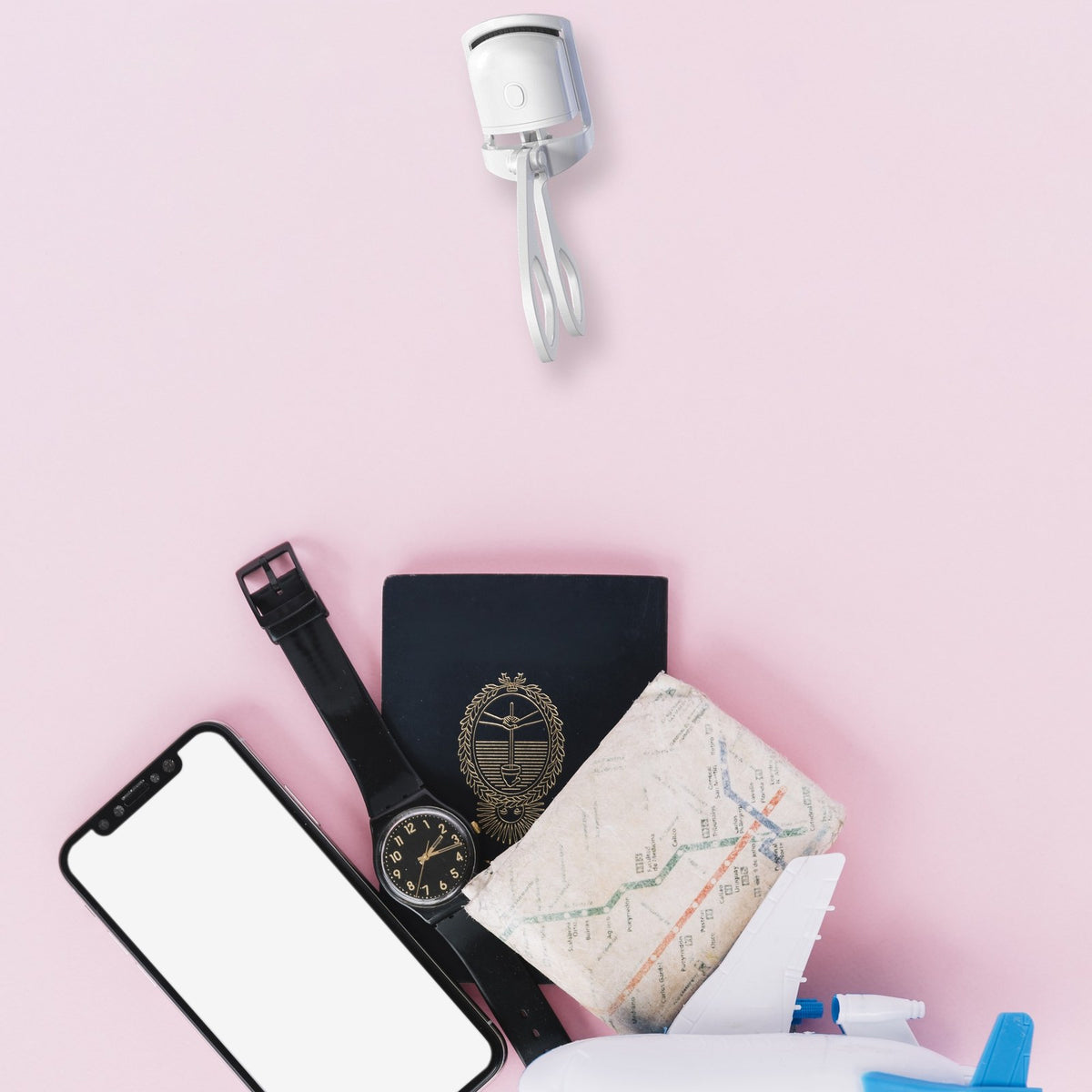 GlowCurl heated eyelash curler next to travel essentials