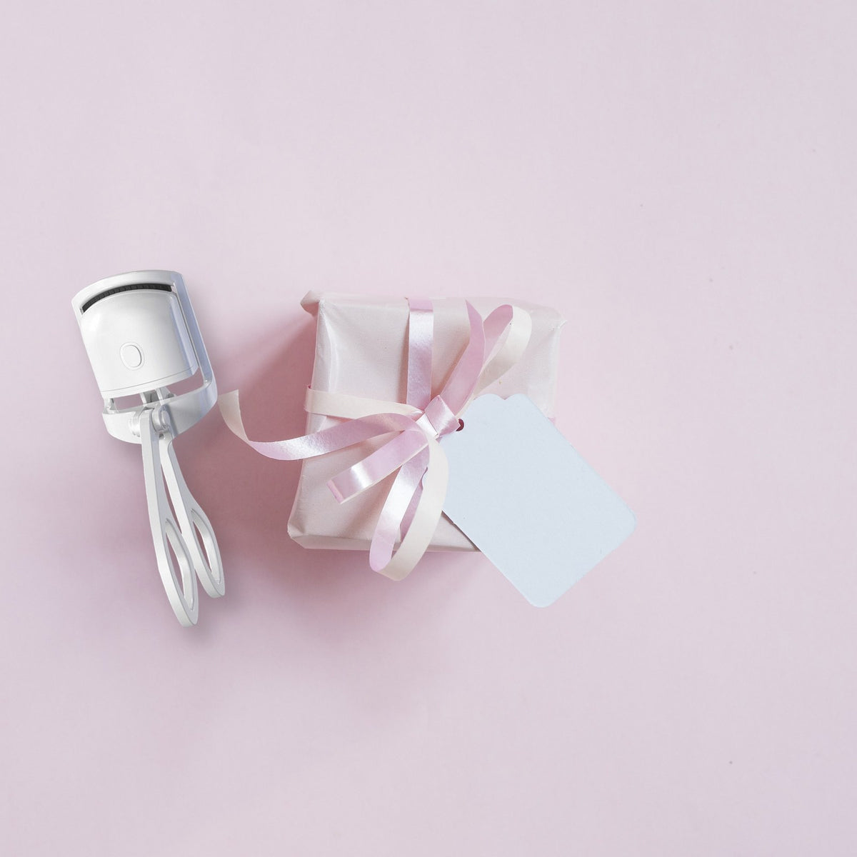 GlowCurl heated eyelash curler beside a ribbon-wrapped gift